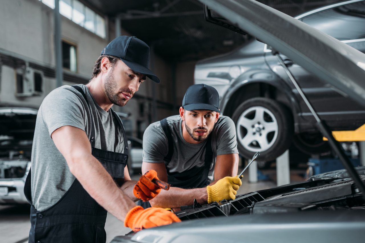 Professional Manual Workers Repairing Car in Mechanic Shop in Clayton
